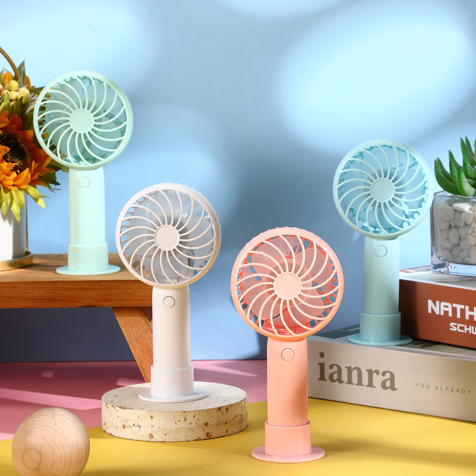 Portable rechargeable handheld fans with base and adjustable speeds for cooling on the go
