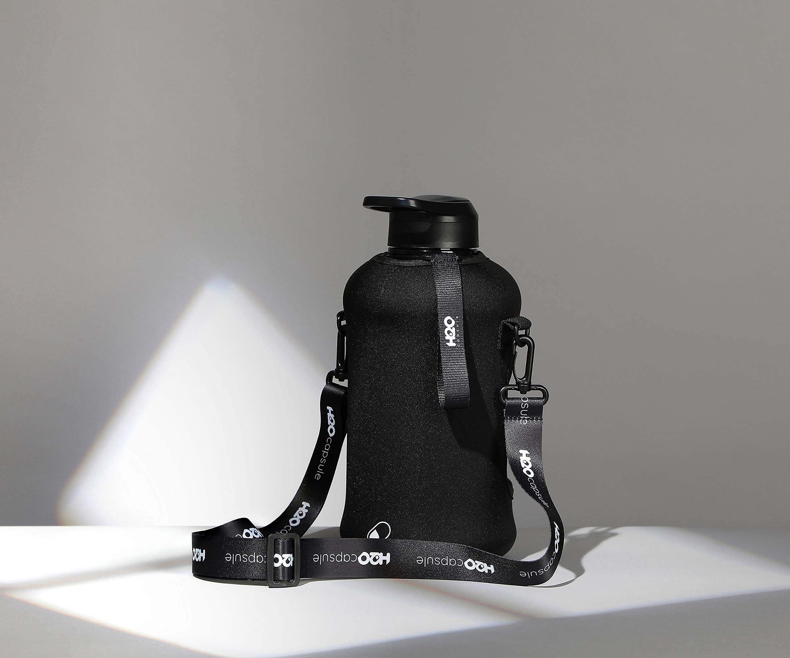 H2O Capsule 2.2L Half Gallon Water Bottle With Storage Sleeve And Covered Straw Lid